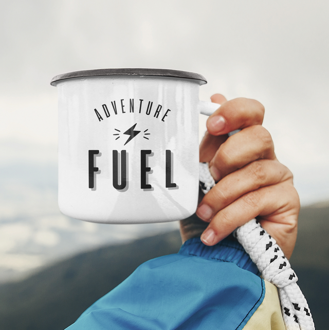 Hand holding enamel mug Adventure Fuel