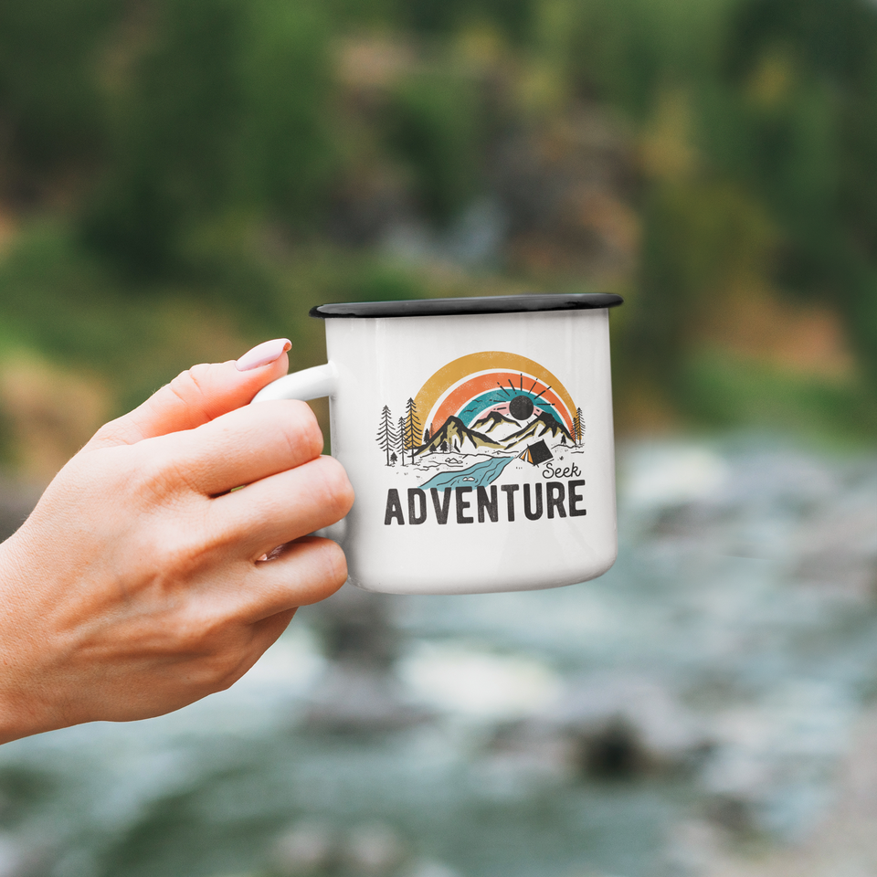 Hand holding enamel mug Seek adventure